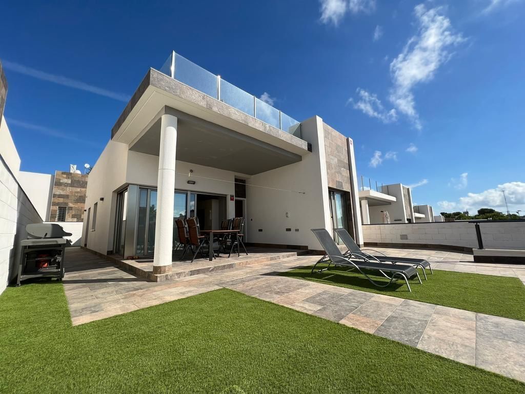 Una casa moderna con un patio, una parrilla y una piscina.