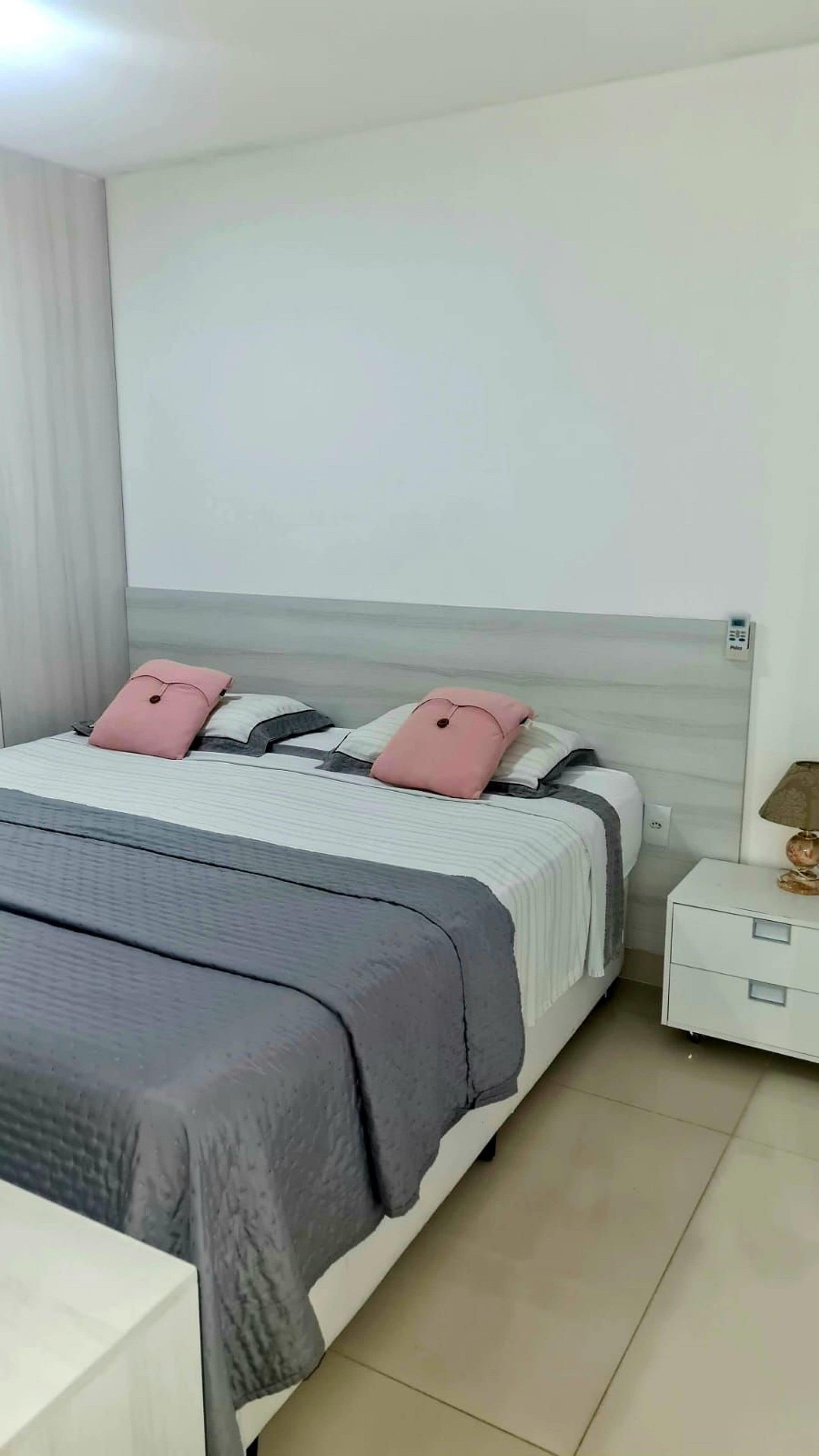 Una camera da letto ordinata con un letto, comodini e una lampada.