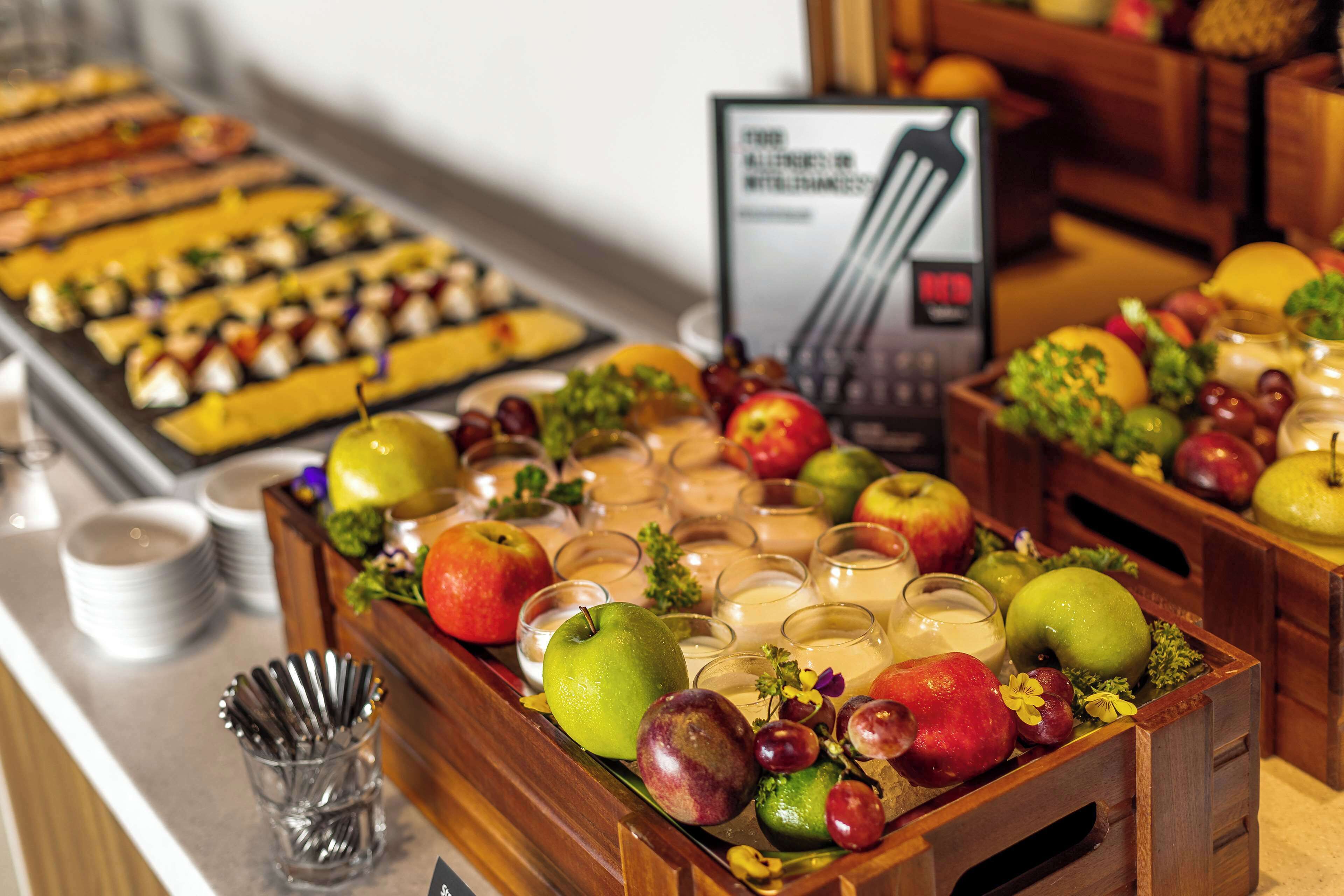 A buffet with a variety of fruits and a signboard in the background.