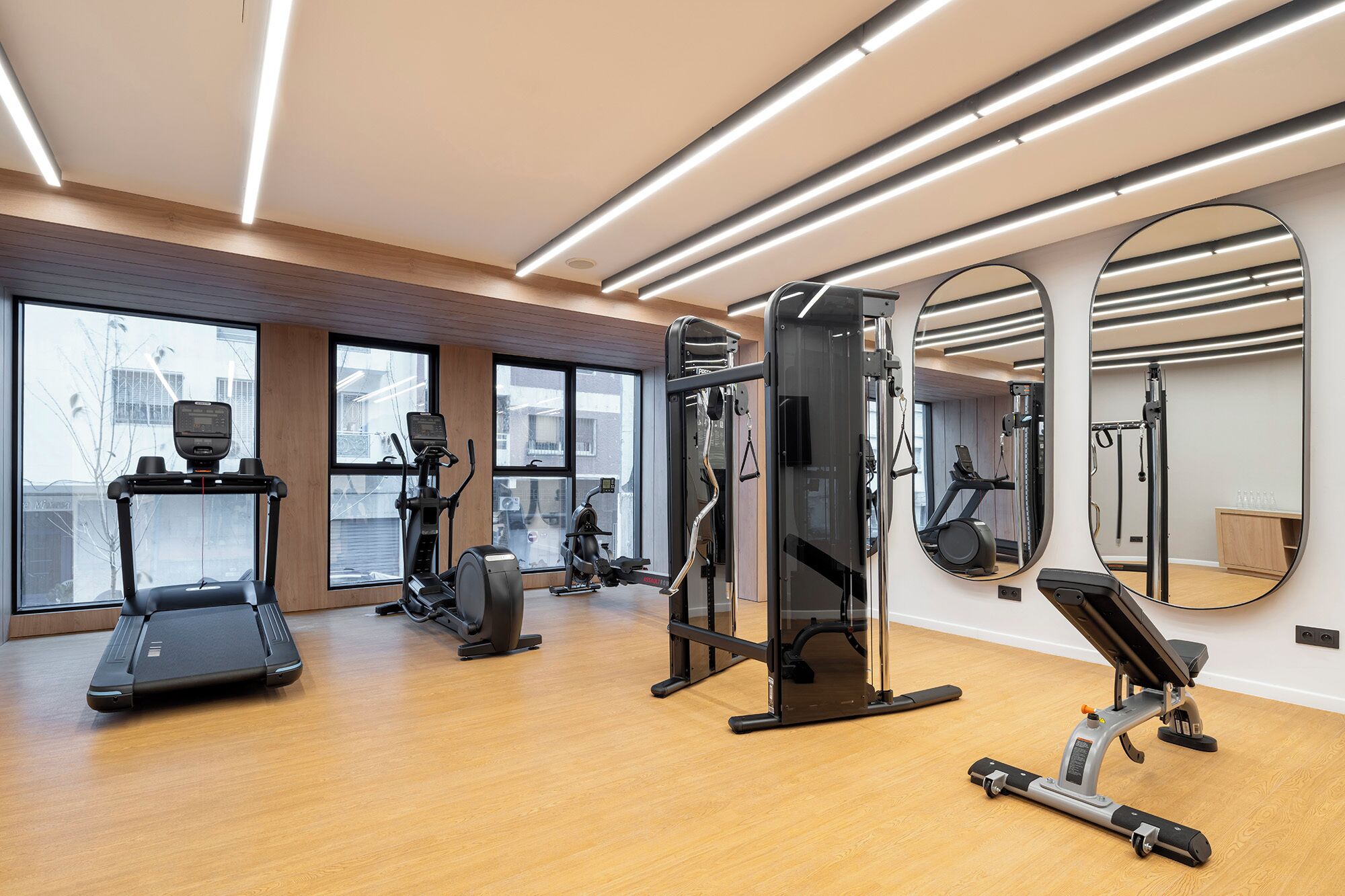Een fitnessruimte met loopbanden, elliptische trainers en gewichten.
