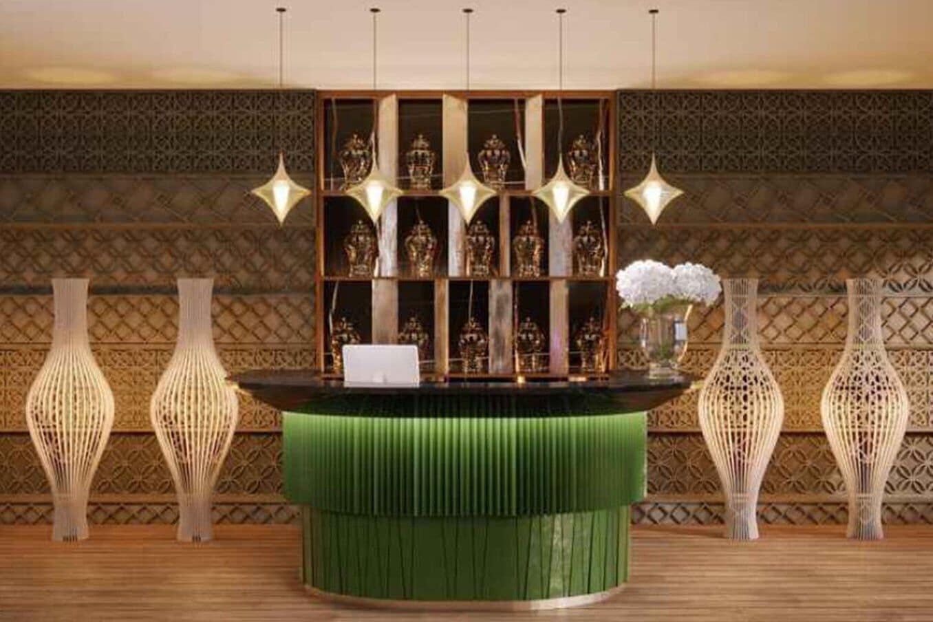 A reception desk with a green cushioned top, surrounded by decorative vases and a patterned wall.