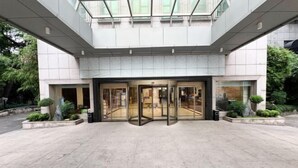 A modern building entrance with a glass door and a tiled floor. - Hangzhou Huaxi Hotel (Yintai Department Store Linping Branch) (Hangzhou)