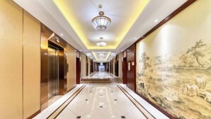 A hotel corridor with a long hallway, elevators, and a mural on the wall. - Hangzhou Huaxi Hotel (Yintai Department Store Linping Branch) (Hangzhou)