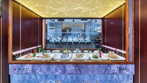 A buffet area with various dishes displayed on plates, a marble countertop, and a glass partition. - Hangzhou Huaxi Hotel (Yintai Department Store Linping Branch) (Hangzhou)