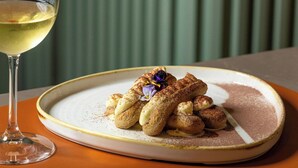 A plate of dessert with a glass of white wine on a table. - Courtyard Milano Linate (Milan)