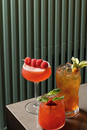 Two cocktails on a table with a vertical striped background. - Courtyard Milano Linate (Milan)