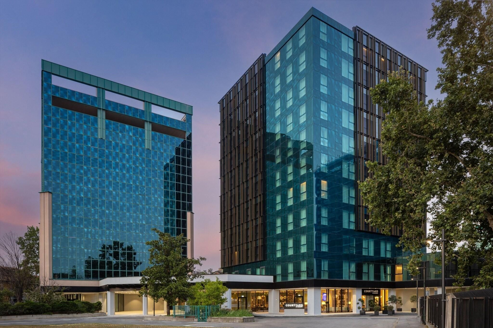 Un edificio moderno con fachada de vidrio y un patio interior.