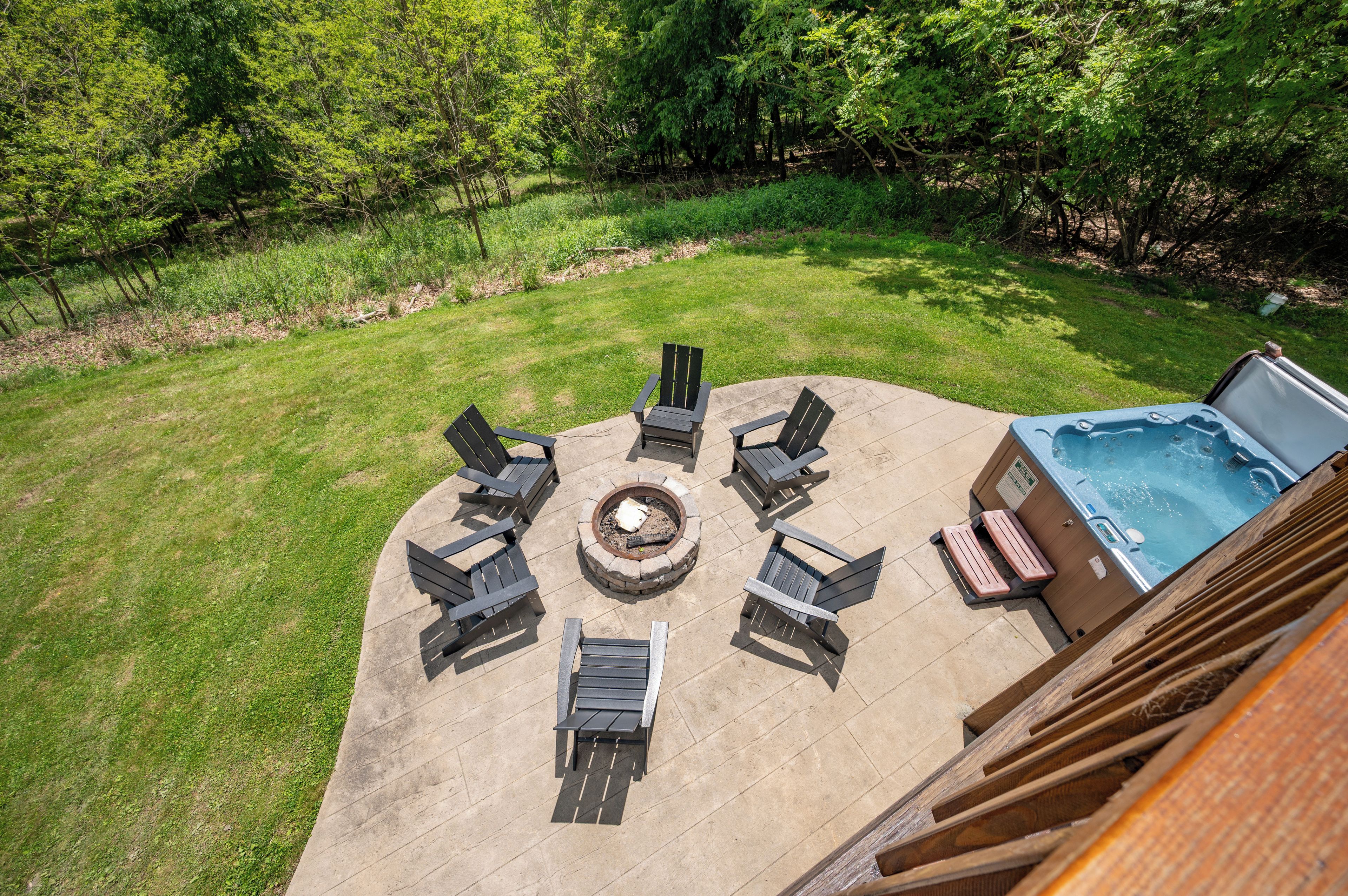 Une terrasse extérieure avec un foyer, des sièges et un jacuzzi.