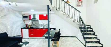 Un interior moderno con una escalera, un comedor y una cocina.