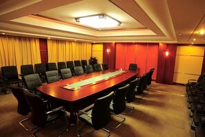 A conference room with a long table, multiple chairs, and a projector screen. - Yunshuijian Hotel (Jiaozuo)