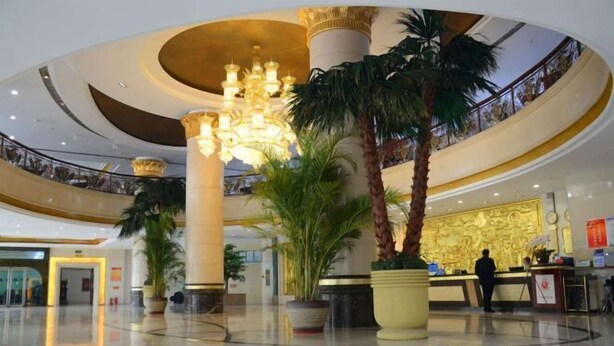 A spacious lobby with a grand chandelier, palm trees, and a reception desk. - Yunshuijian Hotel (Jiaozuo)