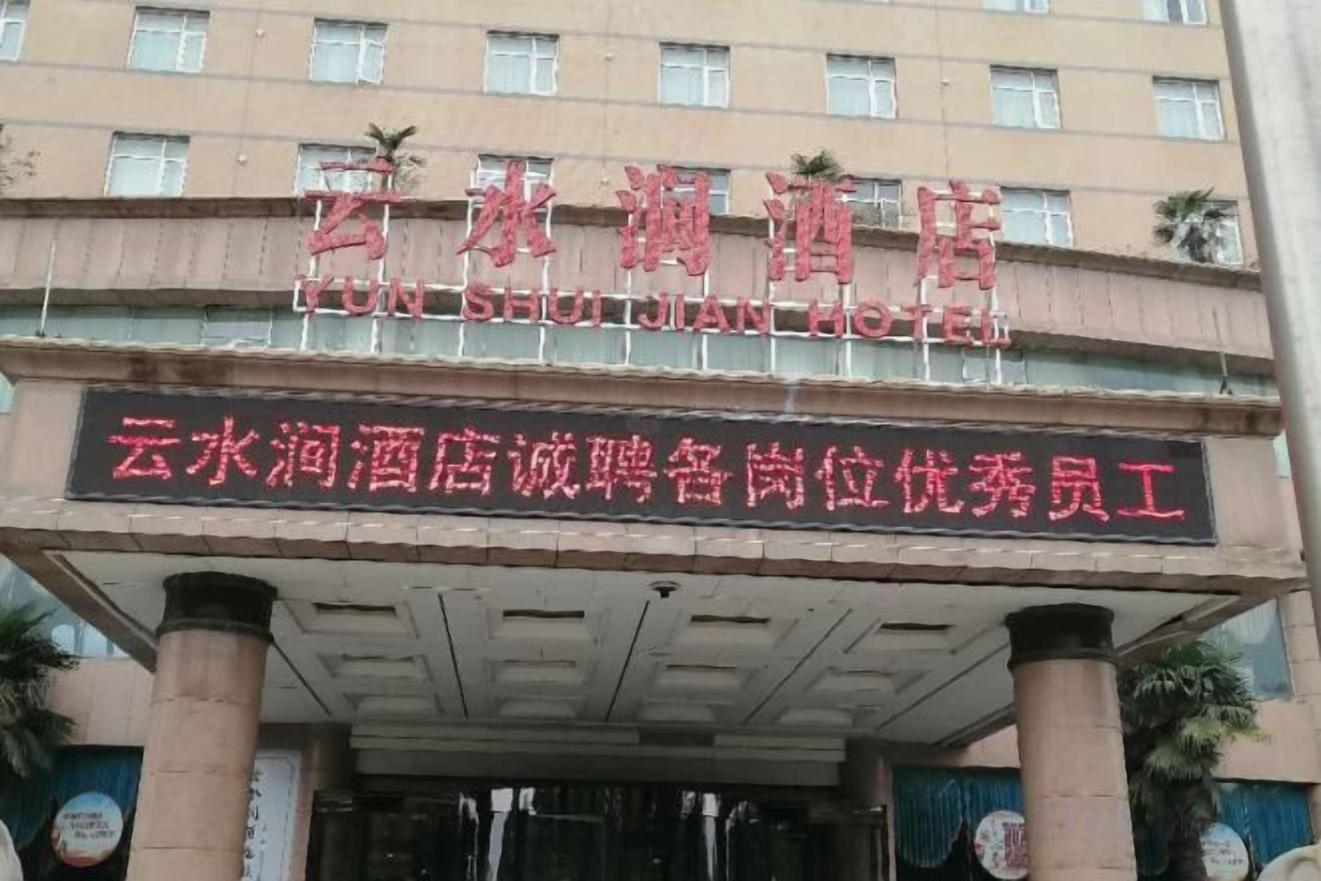Een hotelentree met een bord waarop staat Yulong Hotel.