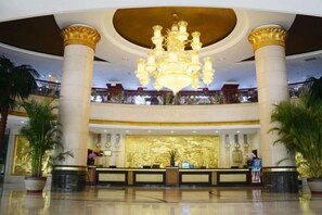 A hotel lobby with a grand chandelier, a reception desk, and a balcony with a railing. - Yunshuijian Hotel (Jiaozuo)