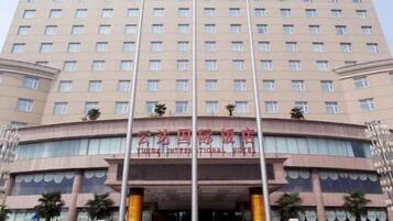 A multi-story hotel with a curved facade, large windows, and a prominent entrance.