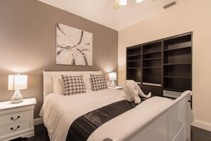 A bedroom with a bed, nightstands, a large abstract painting, and a built-in closet. - Dream House 5 Bedroom w/ Amazing Heated Pool (Hollywood)