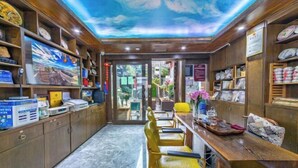 A room with wooden shelves, a marble floor, a long table with yellow chairs, and a ceiling mural. - Weaving Sunshine Vacation Designer Ancient City View Garden Hotel (the Old Town of Lijiang) (Lijiang)