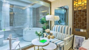 A modern bathroom with a bathtub, a toilet, and a seating area with a teddy bear. - Weaving Sunshine Vacation Designer Ancient City View Garden Hotel (the Old Town of Lijiang) (Lijiang)