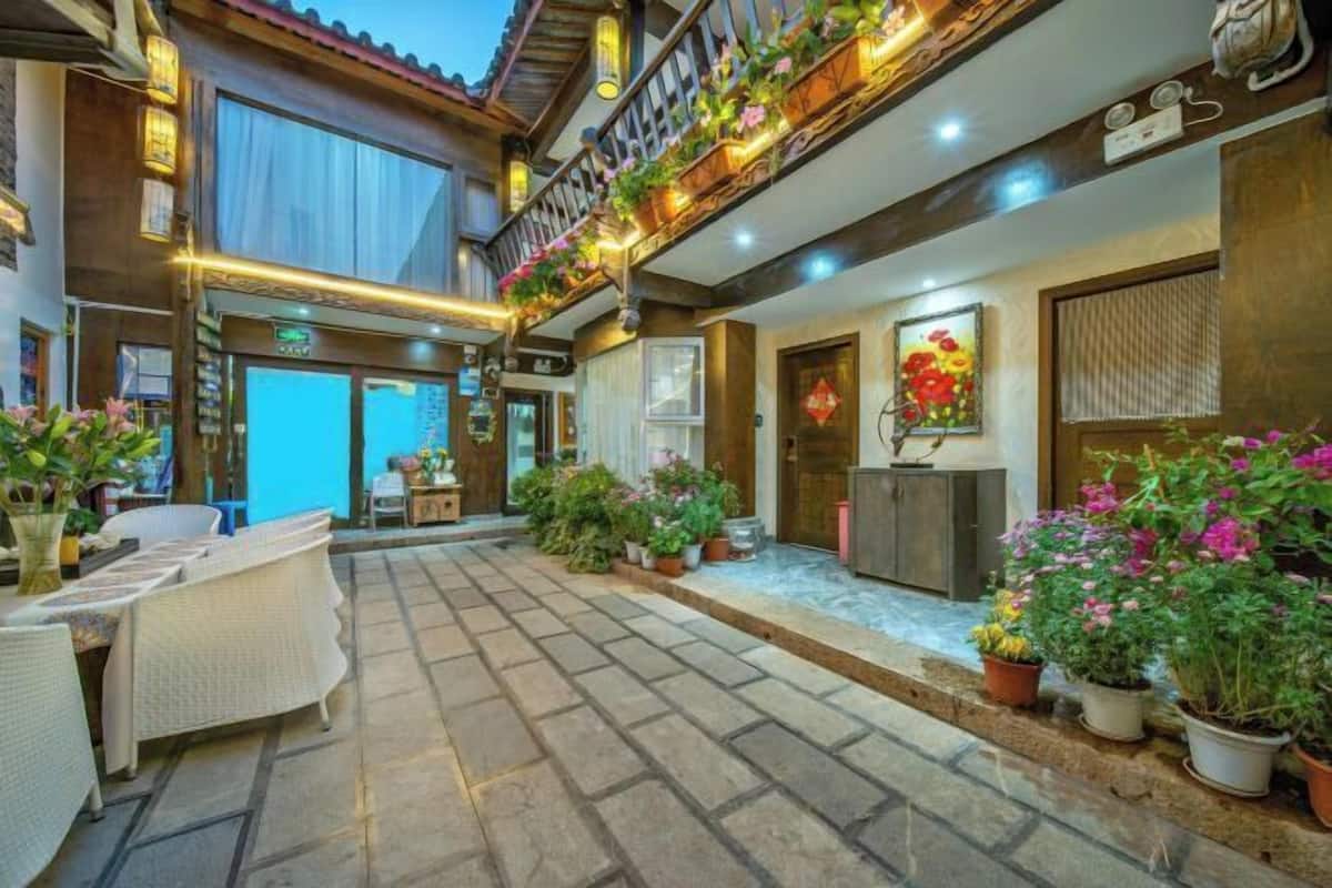 A courtyard with outdoor seating, potted plants, and a building entrance.