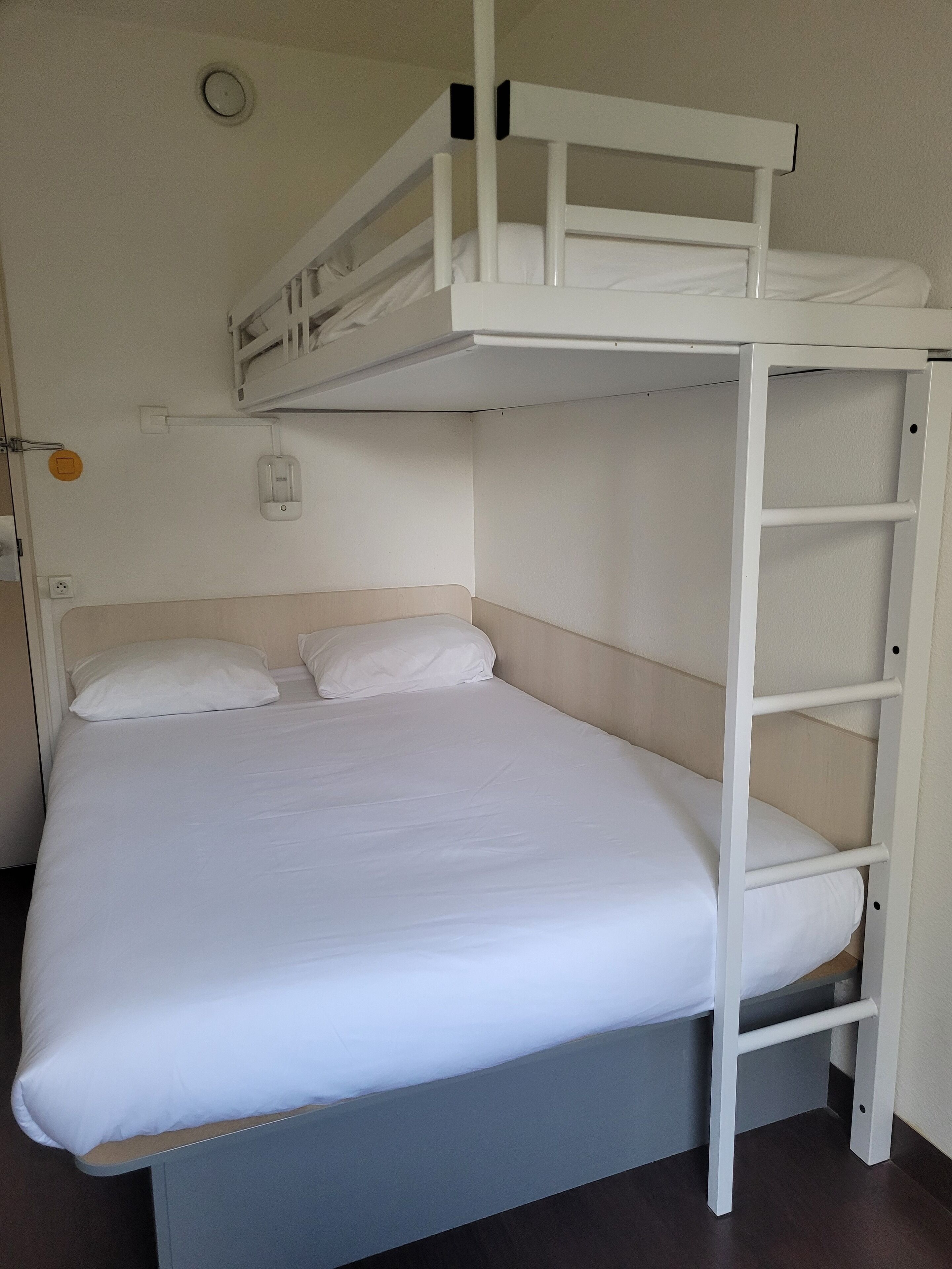A bunk bed with a lower bunk, a headboard, and a mattress.