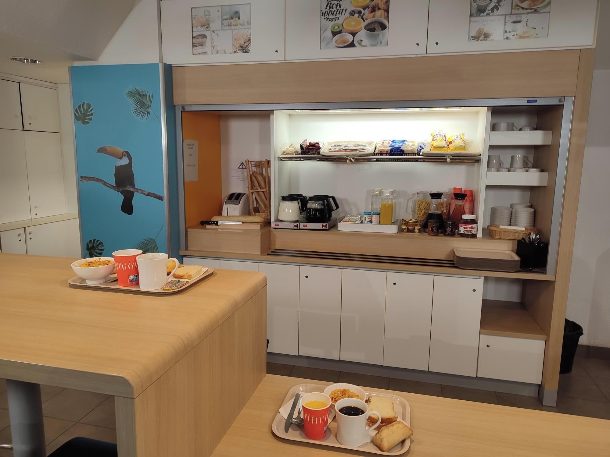 Una barra de desayuno con fuentes de comida, una máquina de café y una exhibición de productos para el desayuno.