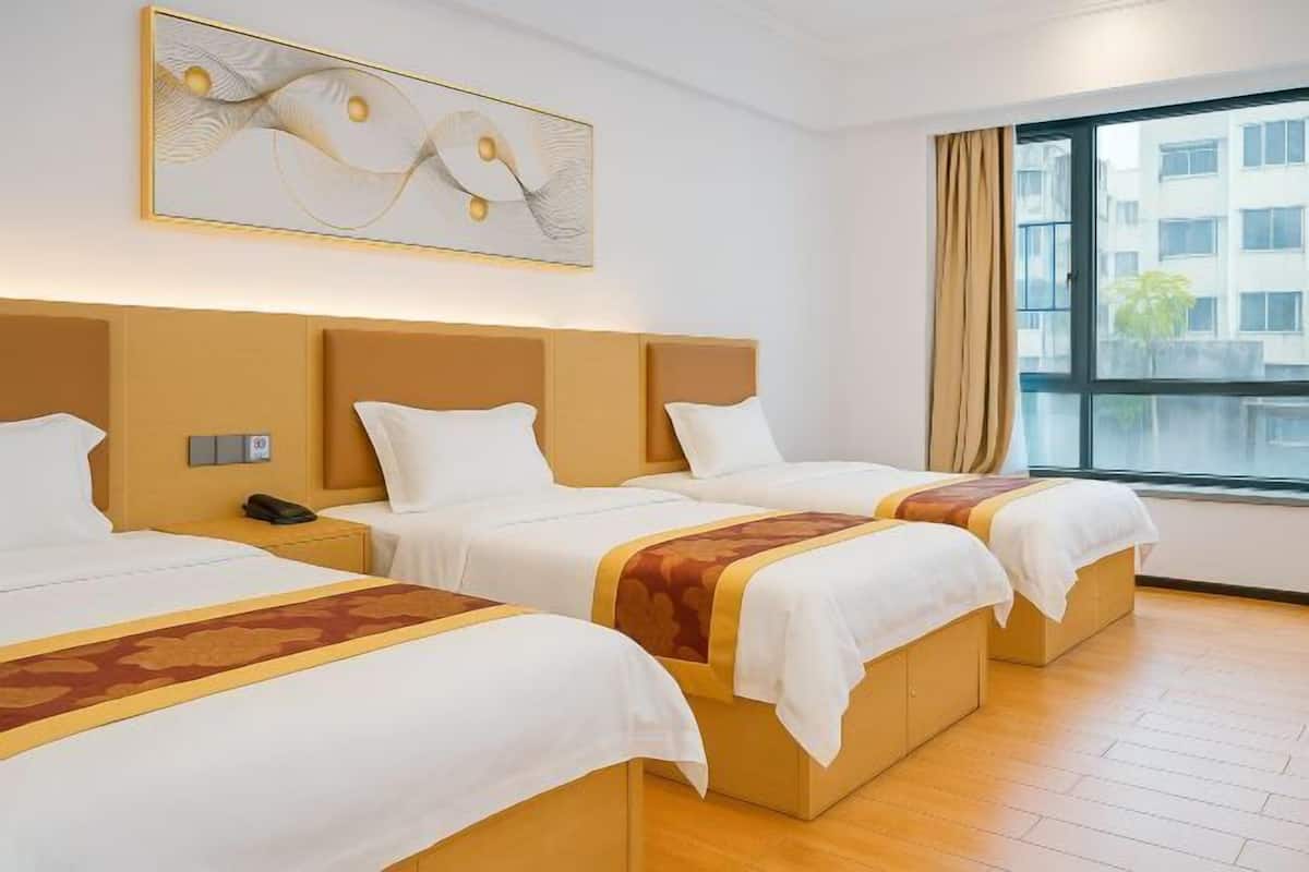 Una habitación de hotel con tres camas, un ventanal grande y un cuadro abstracto moderno en la pared.