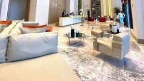 A modern hotel lobby with a reception desk, seating area with sofas and armchairs, and a large window providing natural light. - A705A Awesome DT Doral Apart
 (Doral)