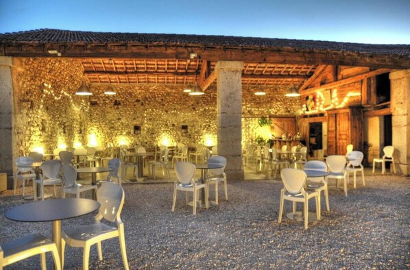 Dine al fresco in a charming outdoor space with round tables and comfortable seating.