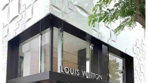 En Louis Vuitton-butik med en modern glasfasad och en svart ram.