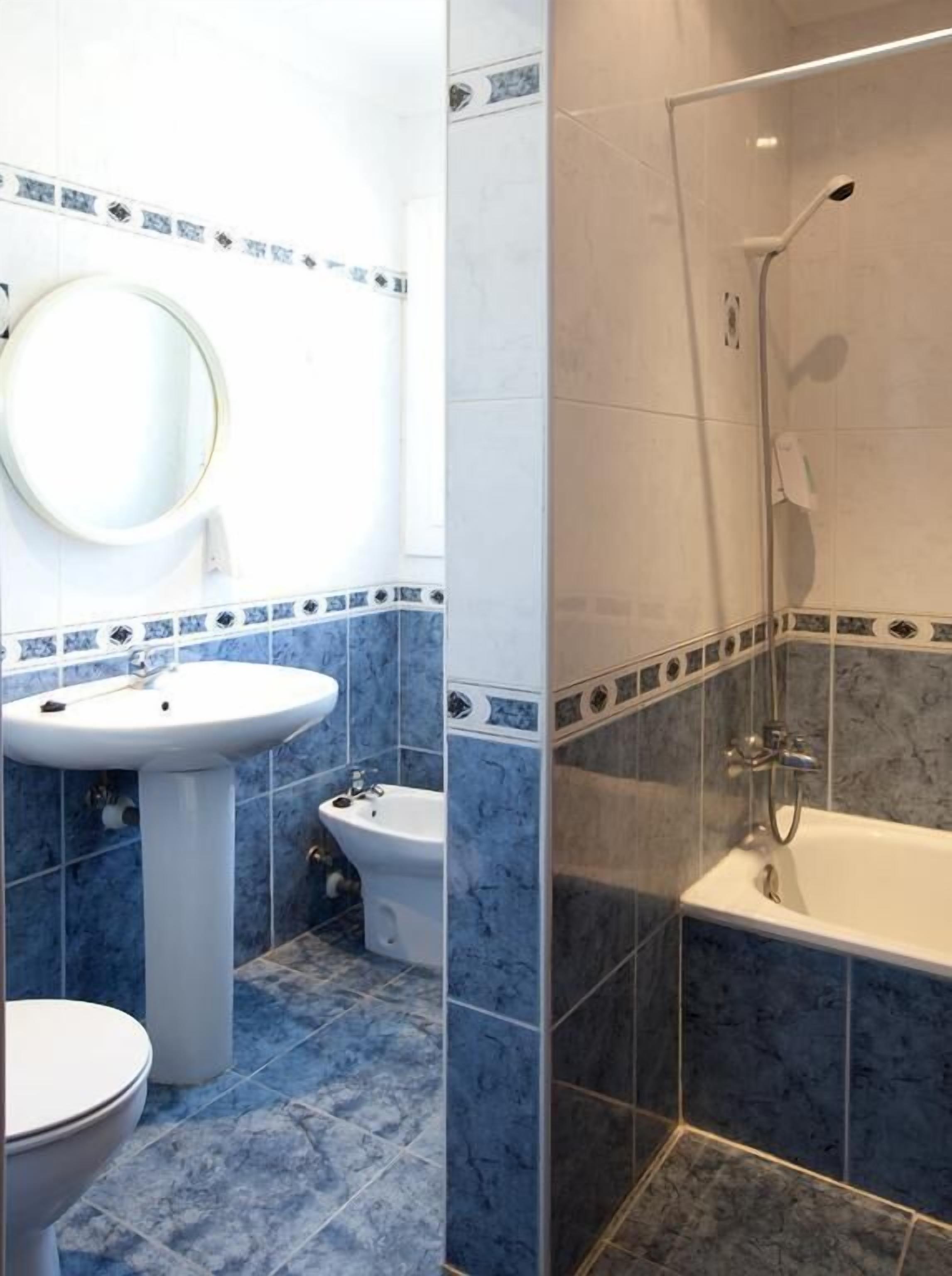 Ein Badezimmer mit Waschbecken, Bidet, Toilette und einer begehbaren Dusche.