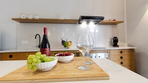 A kitchen with a cutting board, a wine bottle, and two glasses. - Villa Makar Sea View (San Vito Lo Capo)