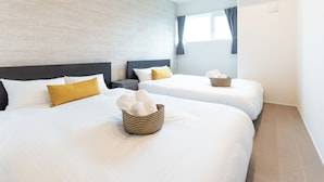 A hotel room with two beds, each with white bedding and a brown woven basket on the bed. - Grandioso Okinawa Pool Villa Onna 13 (Onna)