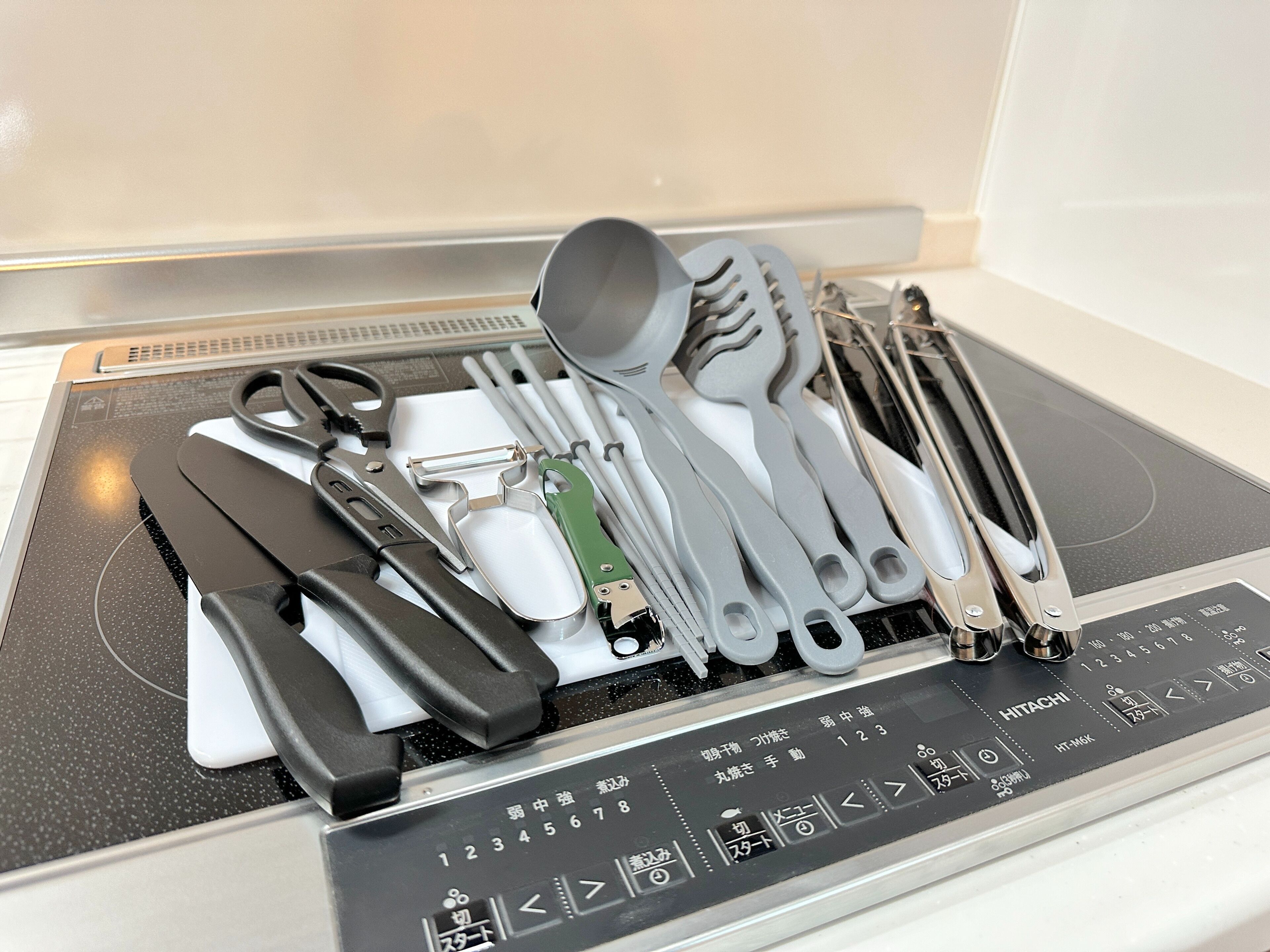 A kitchen with a built-in stove and a variety of utensils neatly arranged on the counter.