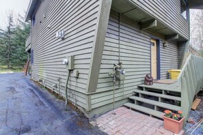 A two-story wooden house with a front porch, a small staircase, and a front door. - Alaskan Cabin Escape w a Hot Tub (Anchorage)