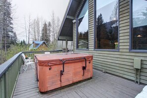 A hot tub on a wooden deck with a house in the background. - Alaskan Cabin Escape w a Hot Tub (Anchorage)