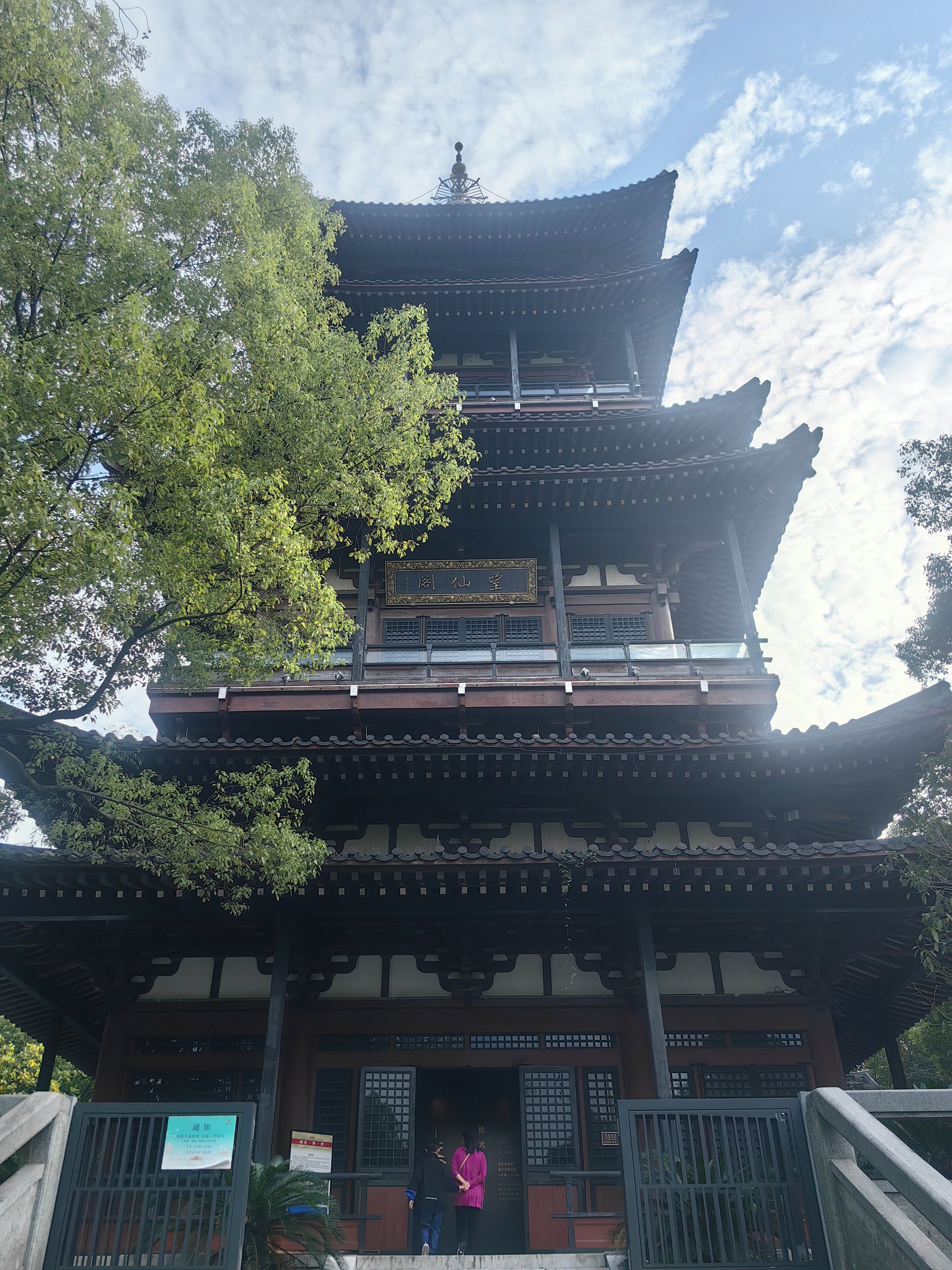 A traditional multi-tiered building with a signboard at the entrance.
