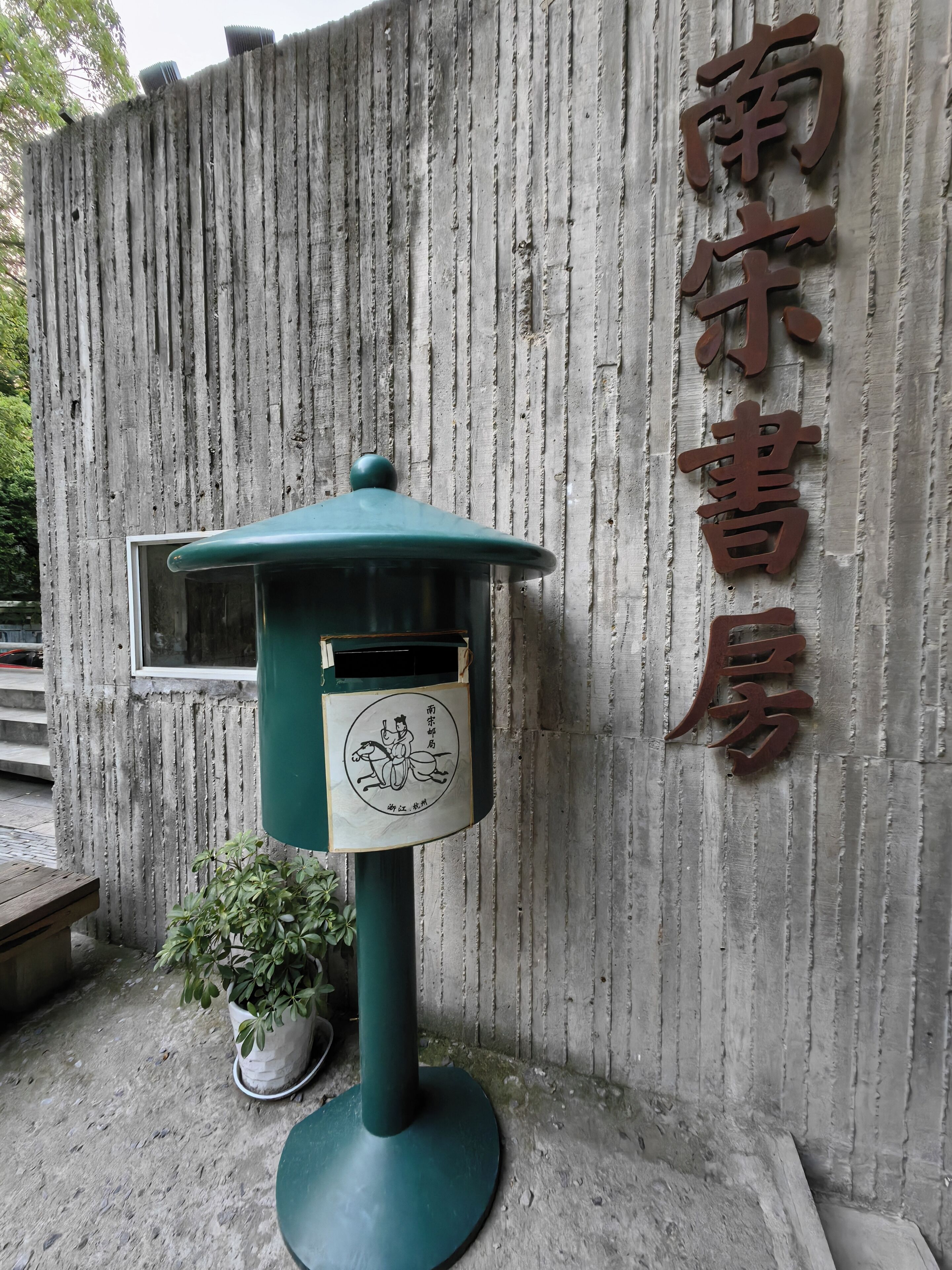 A traditional Chinese building with a signboard and a green lantern.