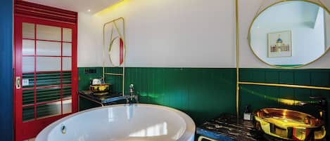 Ein modernes Badezimmer mit einer großen Badewanne, einer roten Tür und einer grünen Wand.