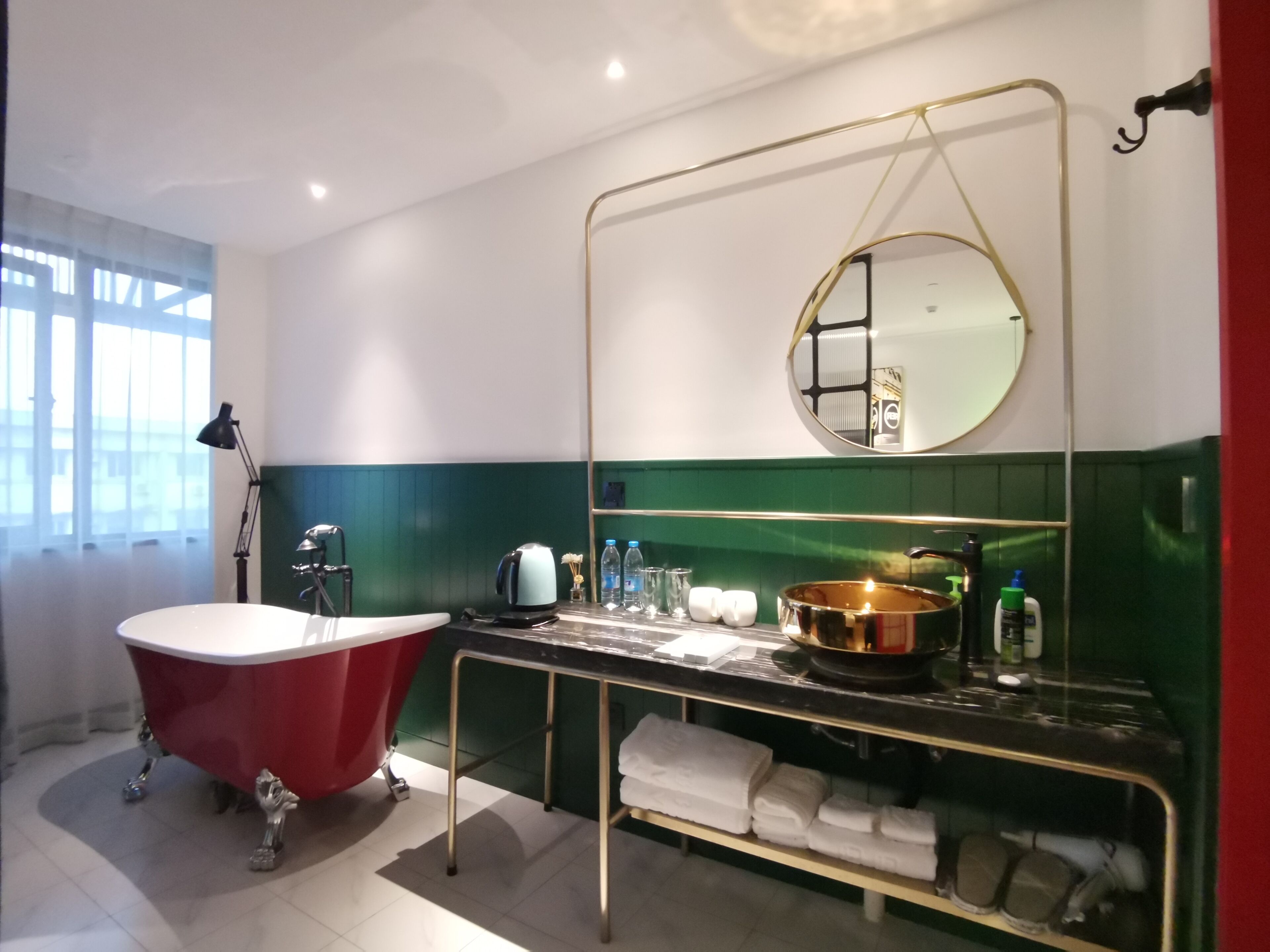 A bathroom with a freestanding bathtub, a vanity with a mirror, and a sink.