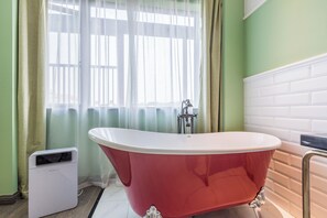 A bathroom with a red clawfoot bathtub, a white pedestal sink, and a white heater. - Zheda Yuanzheng Lanshe Hotel  (Hangzhou)