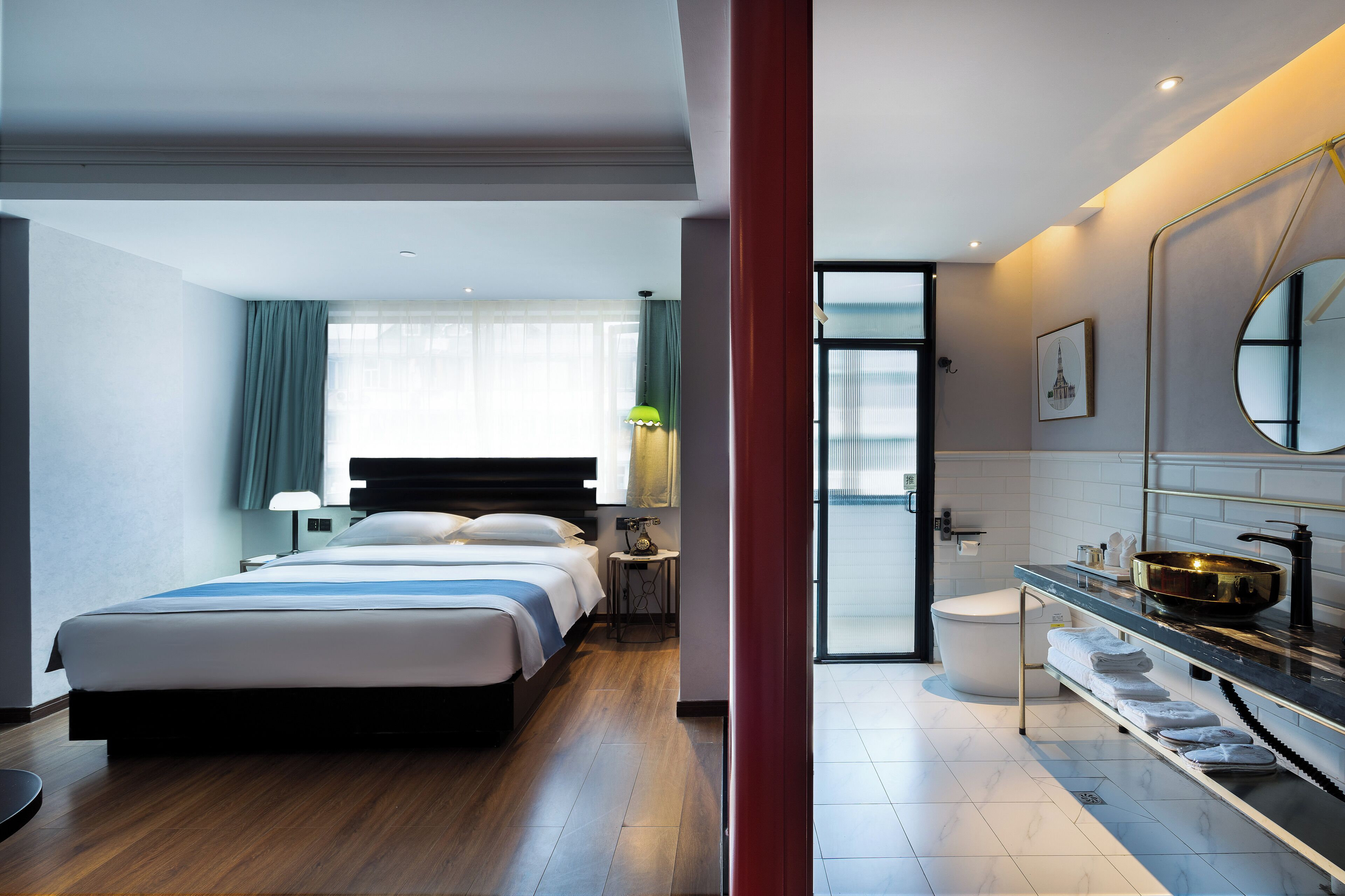 Ein modernes Hotelzimmer mit einem großen Bett, einem Badezimmer mit Badewanne und Blick auf die Stadt.