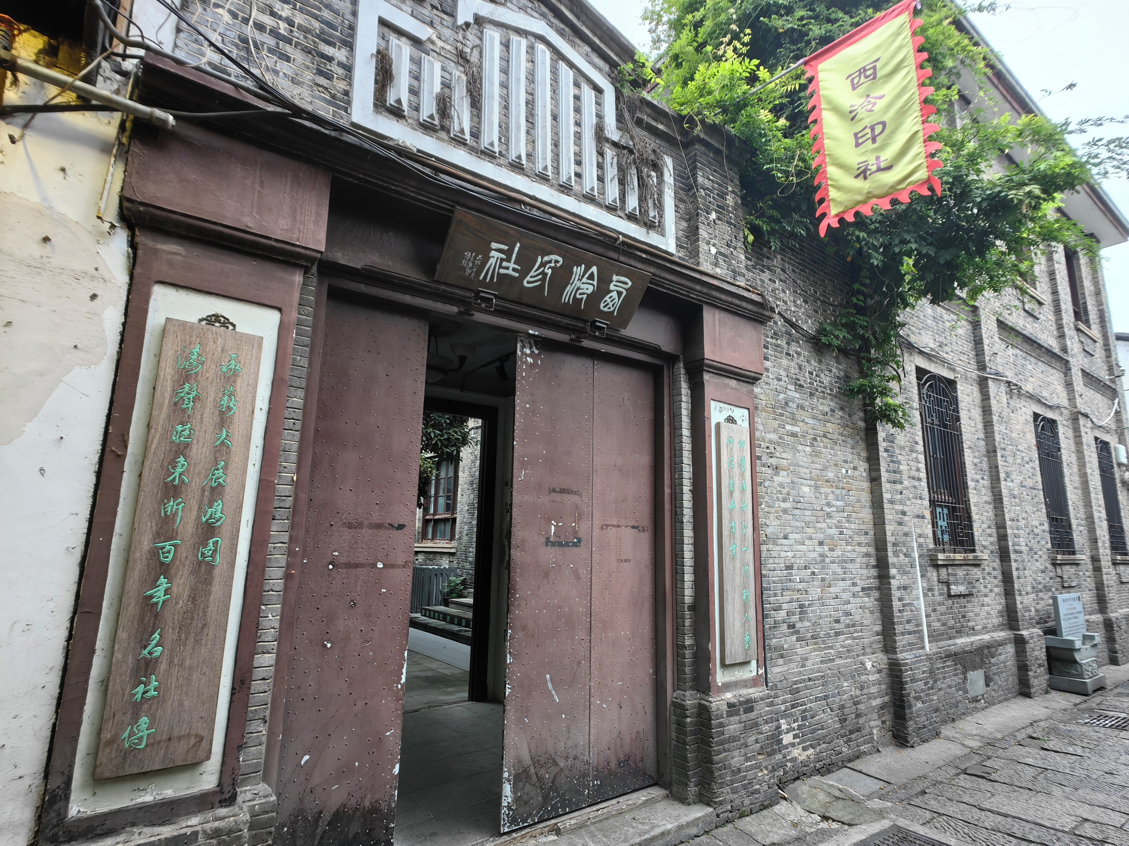 A building with a large wooden door and a sign above it.