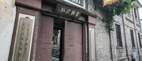 A building with a large wooden door and a sign above it.