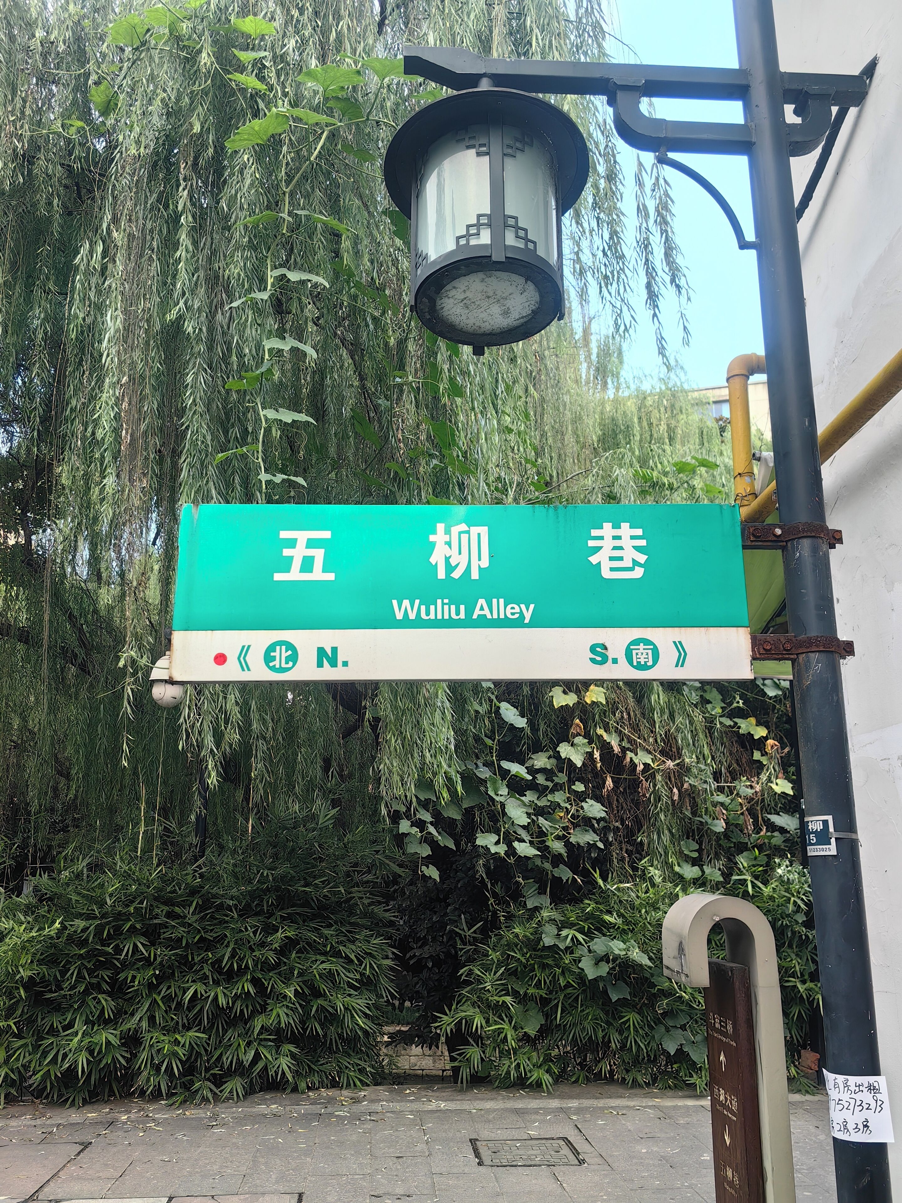 A street sign for Wuliu Alley with directional arrows pointing north and south.