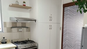 A kitchen with white cabinets, a gas stove, and a stainless steel oven.