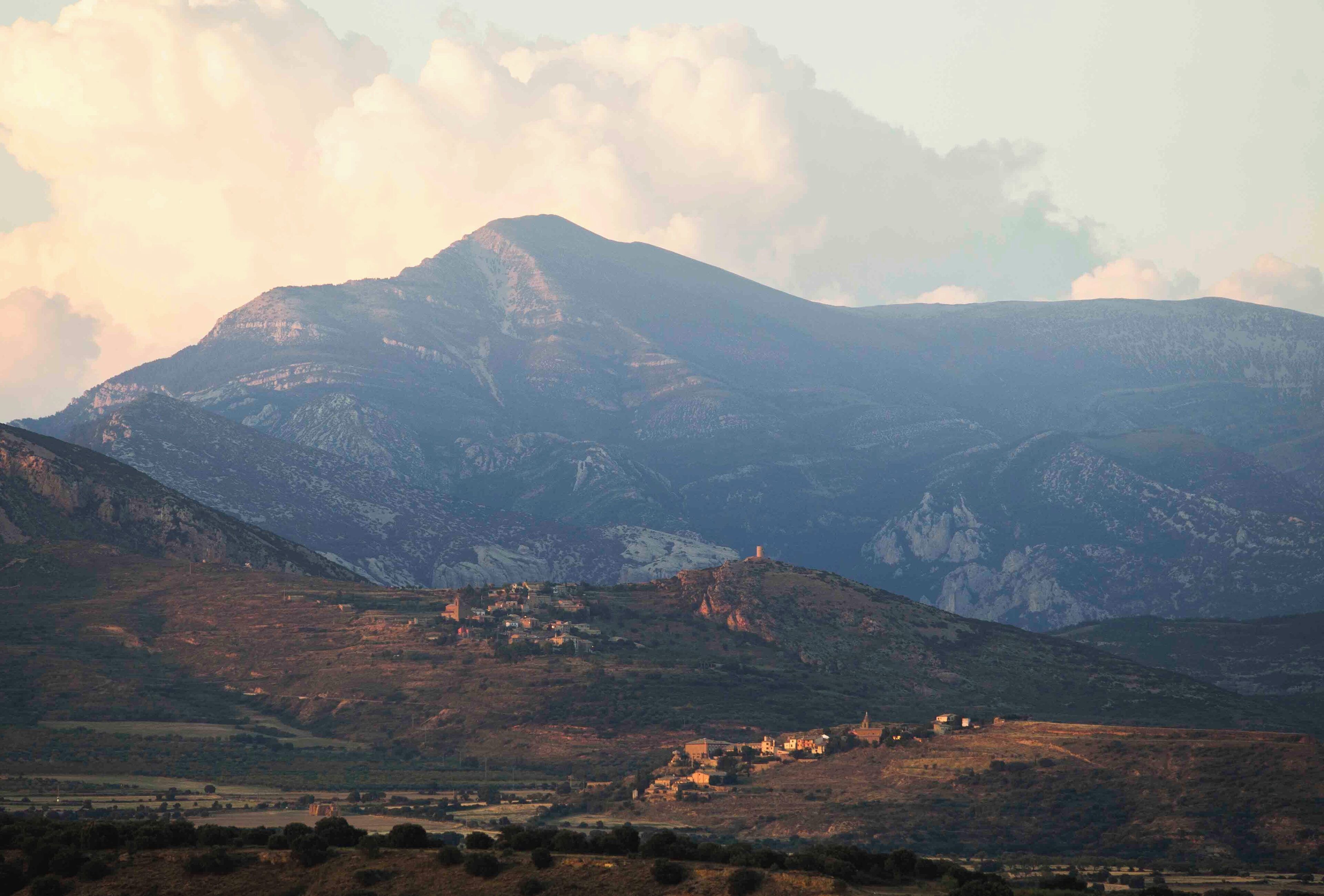 Un paisaje montañoso con un pueblo ubicado en el valle.