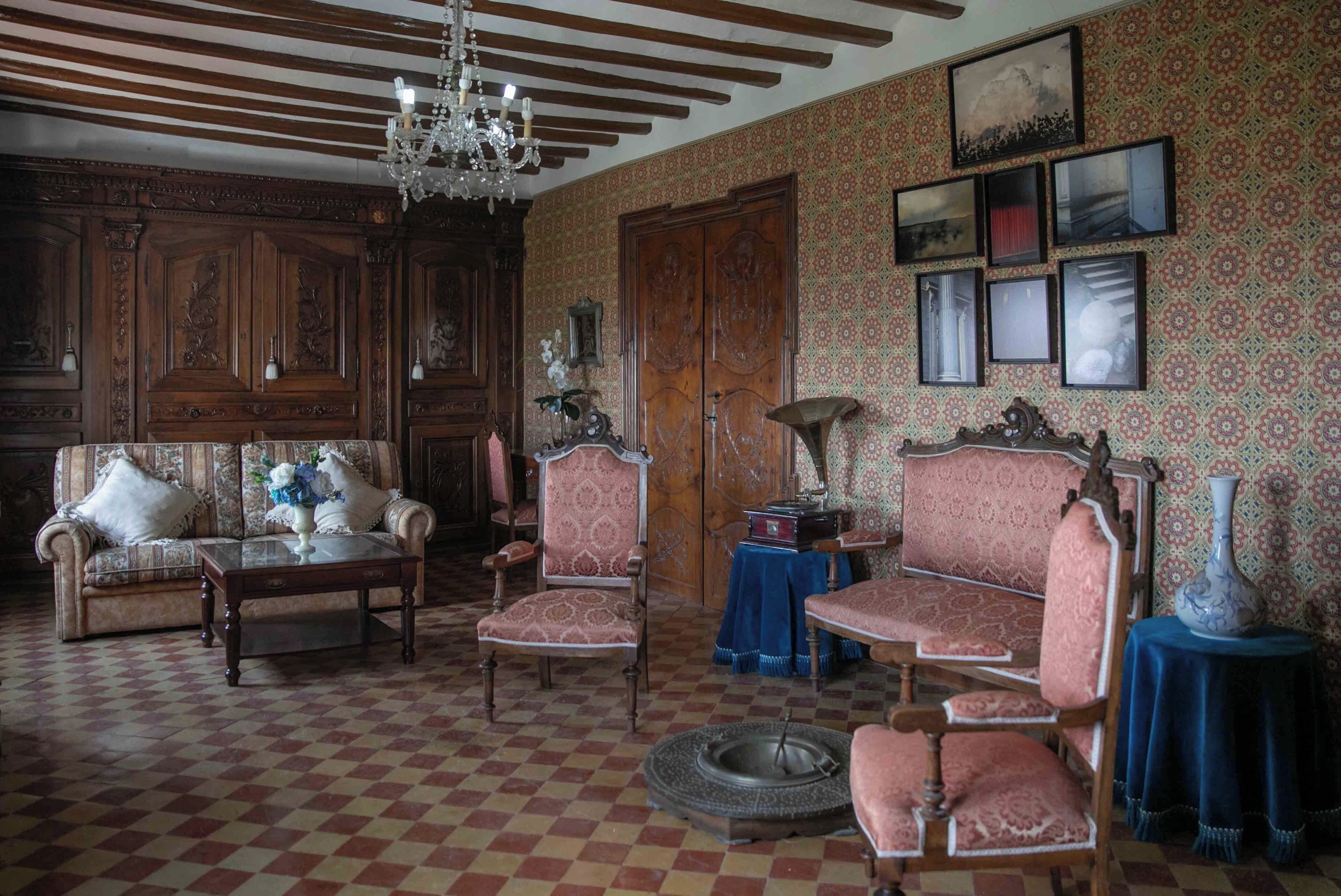 Una habitación tradicional con suelo a cuadros, muebles de madera y papel tapiz estampado.
