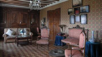 Una habitación tradicional con suelo a cuadros, muebles de madera y papel tapiz estampado.