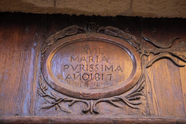 A carved wooden plaque with the inscription "AVE MARIA PMRISSIMA AO1817".