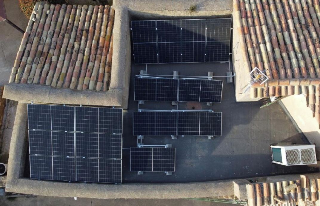 Una azotea con paneles solares y una unidad de aire acondicionado pequeña.