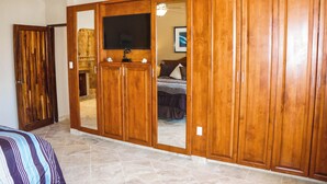 Ein Schlafzimmer mit Holzschrank, Bett und Fernseher.